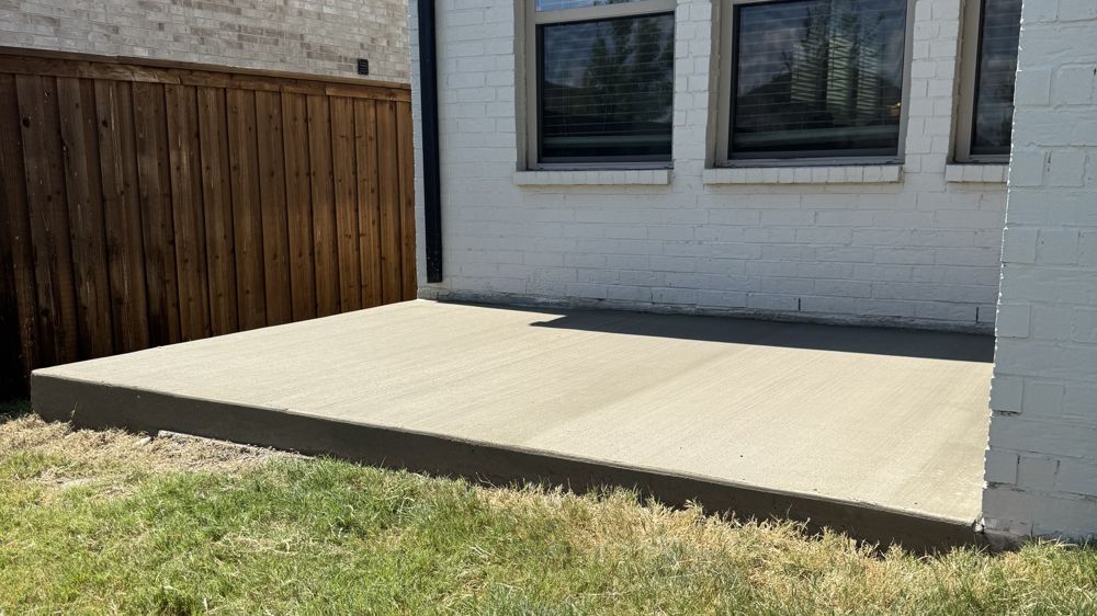 New Coyote concrete patio behind a brick home