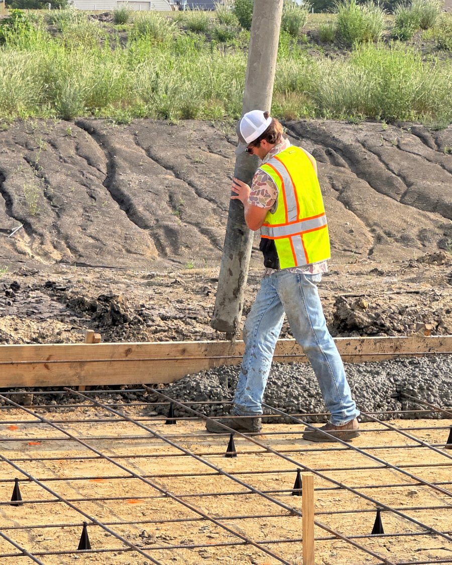 Coyote Concrete's owner guiding the pump hose during a pour