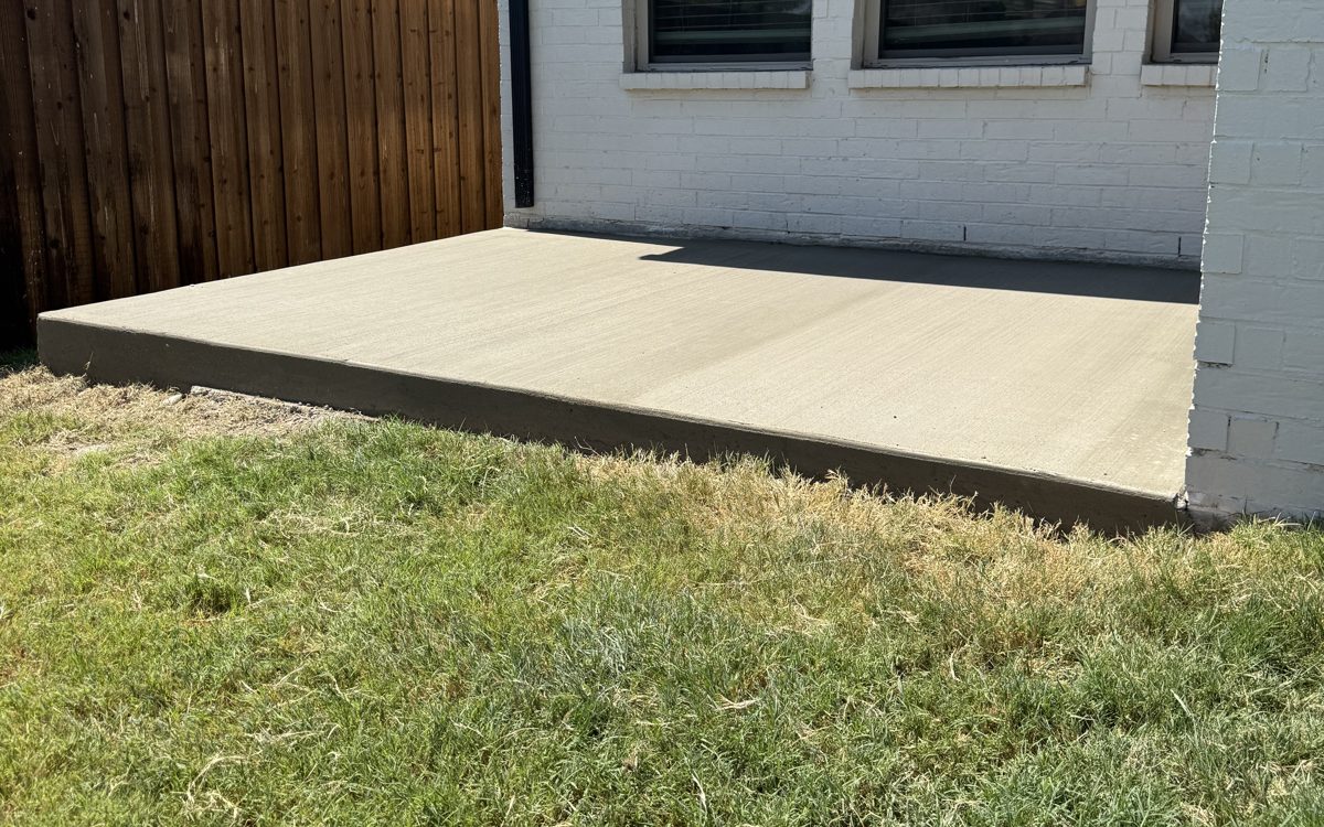 New patio slab in the corner beside the covered patio